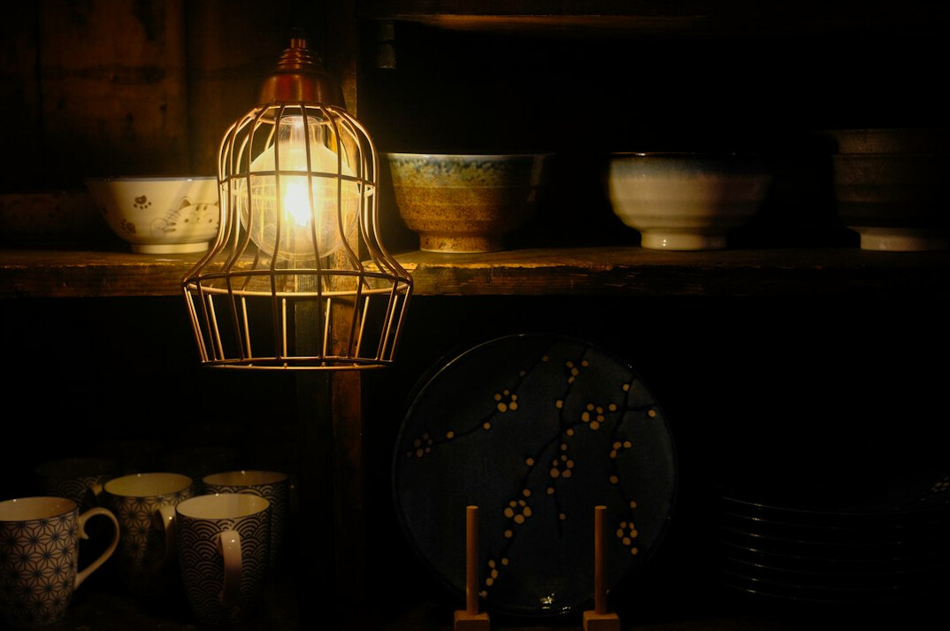 Lamp and books on a dark shelf