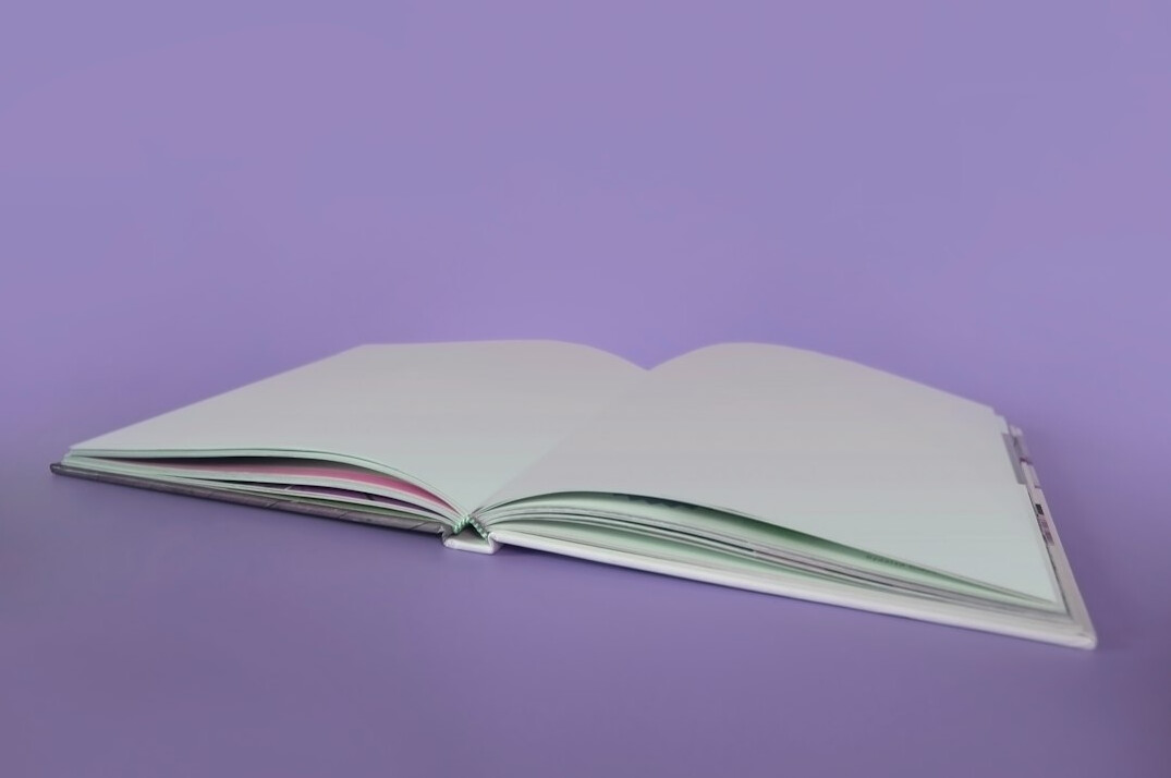 Open notebook and books on a wooden desk